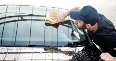 Man wiping windscreen clean with a soft cloth