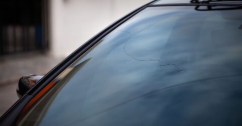 Long curvy crack in a windscreen of a car.