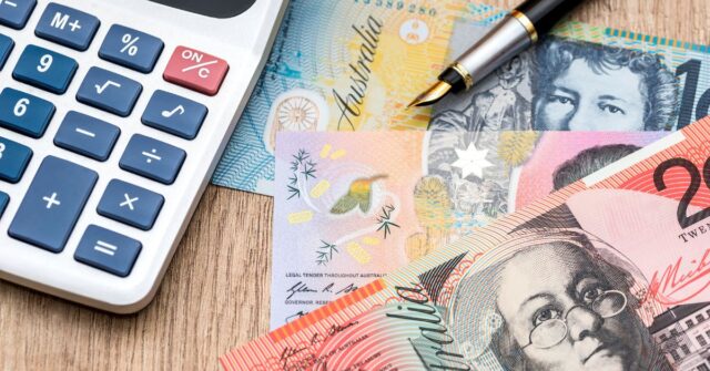 Australians dollars and a calculator in a wooden background.