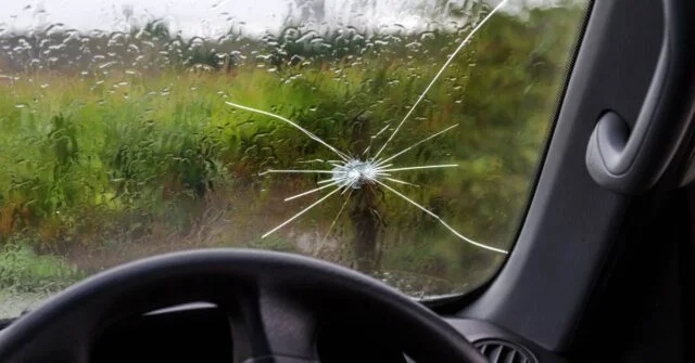 A cracked windscreen of a car that needs repair.