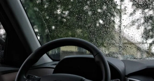 Car windshield with blurry windscreen due to raindrops.