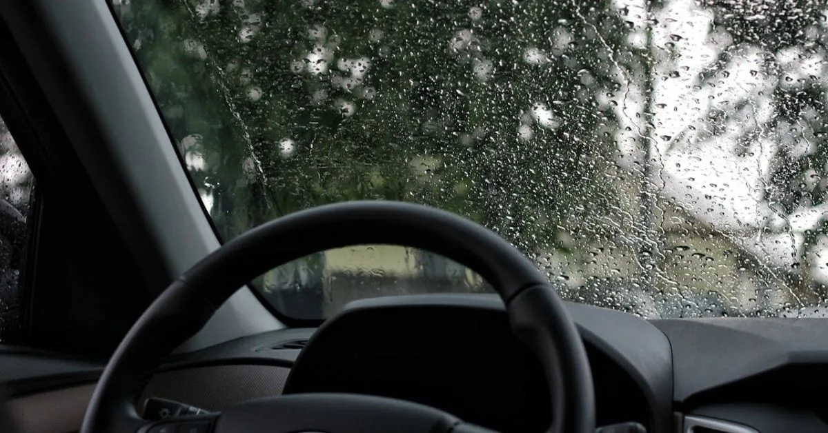 Car windshield with blurry windscreen due to raindrops.