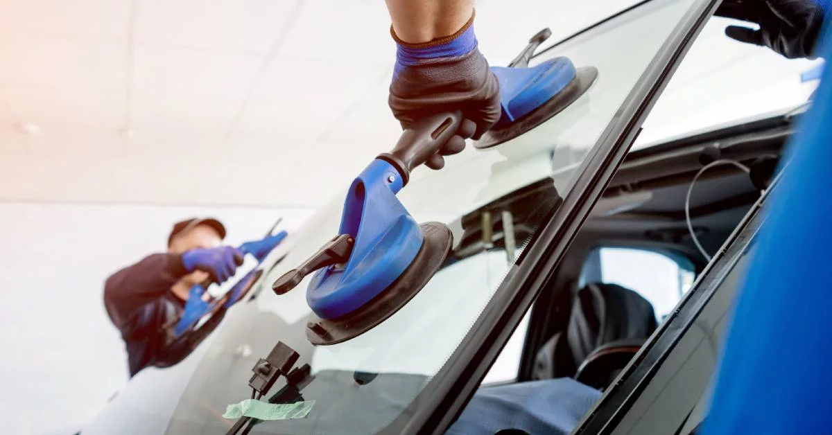 Automobile special workers replacing windscreen or windshield of a car.