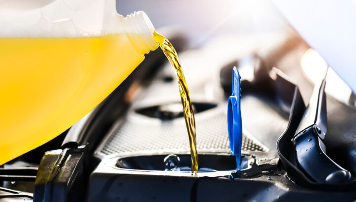 Pouring summer liquid or yellow car fluid for washing car screen.