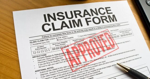 Insurance claim form with Approved stamped on it in red ink.