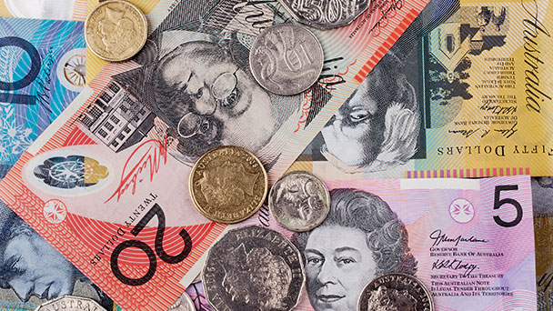 A mix of bank notes and coins on table.