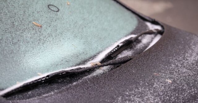 Windscreen with a large build up of frost which has built up on the glass and windscreen wipers.