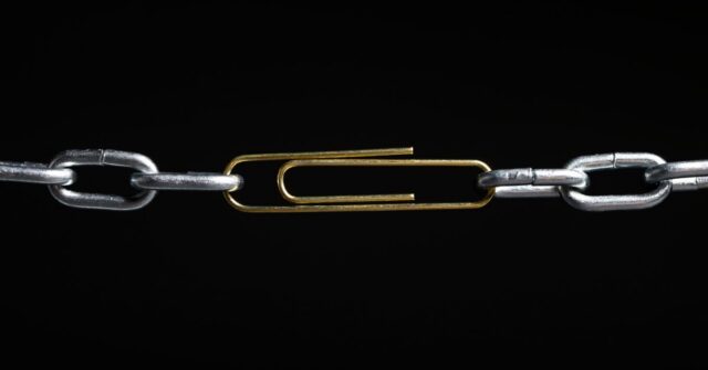 Metal chain with a paperclip holding the two ends together, indicating that a chain is only as strong as its weakest link.