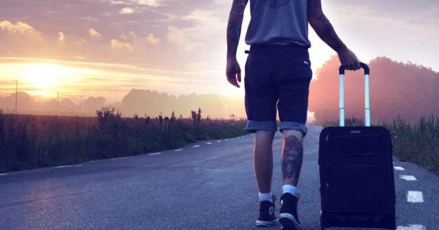 Man on a road trip wheeling his luggage