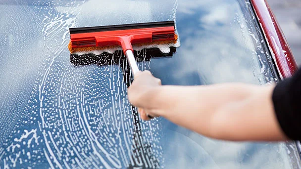 Person's washing their car windscreen with a squeegee