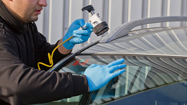 Repairer inspecting dmage and preparing chip repair equipment.