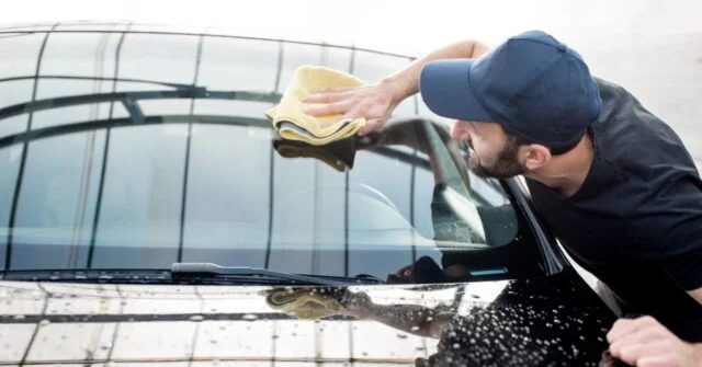 Man wiping windscreen clean with a soft cloth