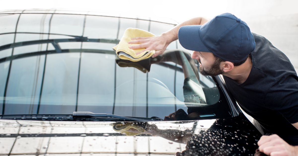 Man wiping windscreen clean with a soft cloth